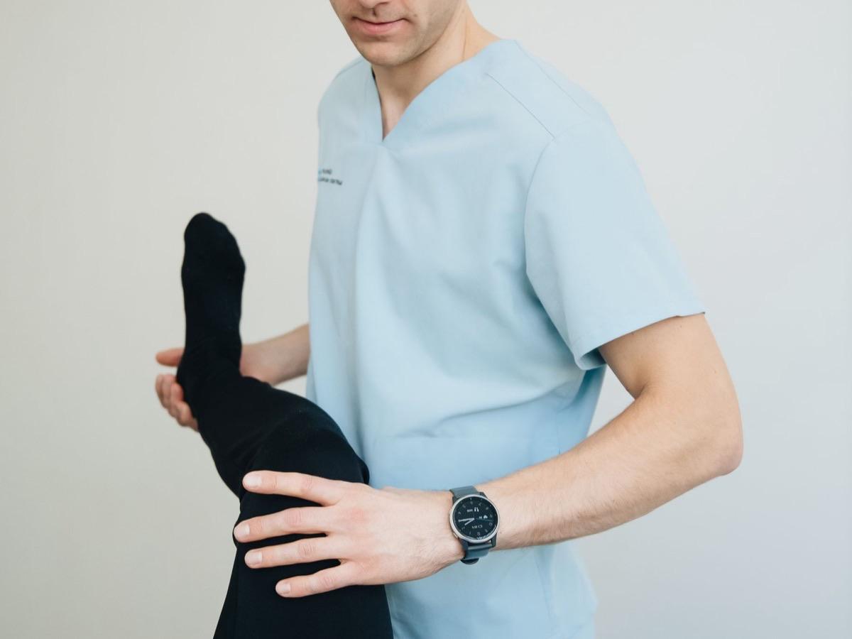Physical therapist guiding a patient through knee exercises during post-surgical rehabilitation