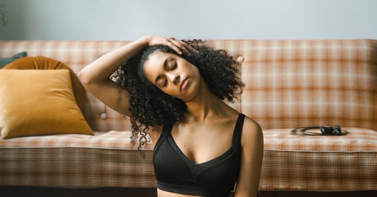 Woman doing a gentle seated neck stretch at home